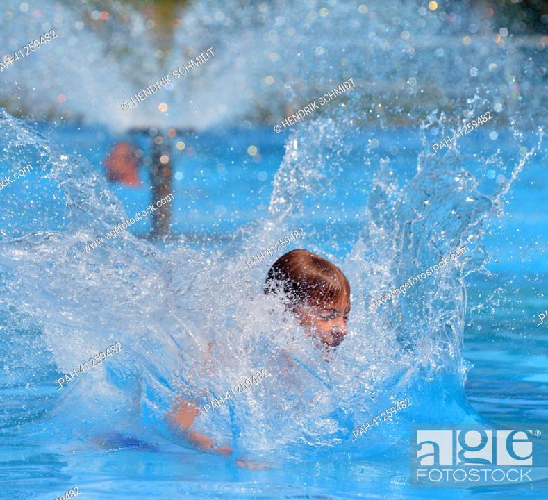 Stock Photo: A boy jumps into the water in the bath of Rebesgruen, Germany, 24 July 2013. This weekend the 17th German water sliding championship will take place in the bath.