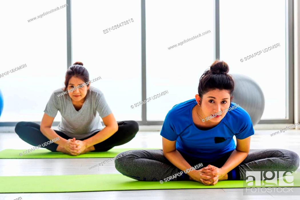 Stock Photo: Two Asian women sporty attractive people practicing yoga lesson together, working out at the fitness GYM, Young and senior female exercising do yoga in yoga.