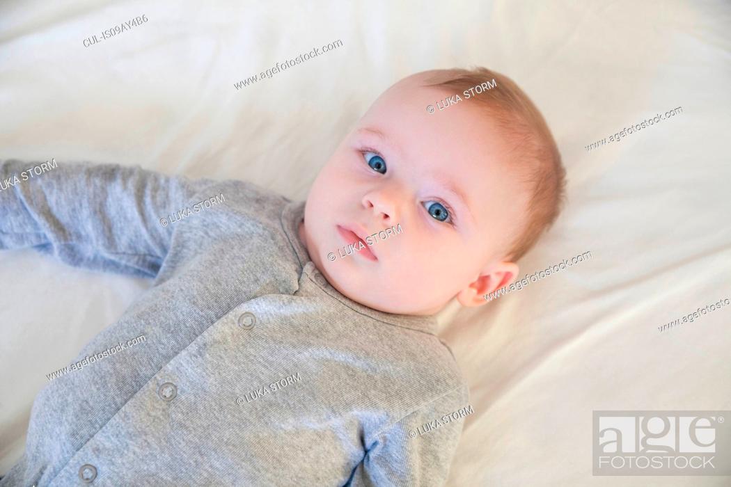 Overhead portrait of blue eyed baby boy lying on bed, Stock Photo, Picture  And Royalty Free Image. Pic. CUL-IS09AY4B6 | agefotostock
