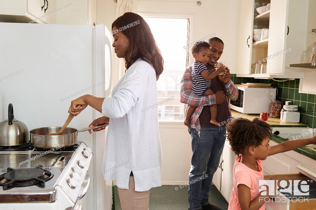 Stock Photo: Family At Home Preparing Meal In Kitchen Together.