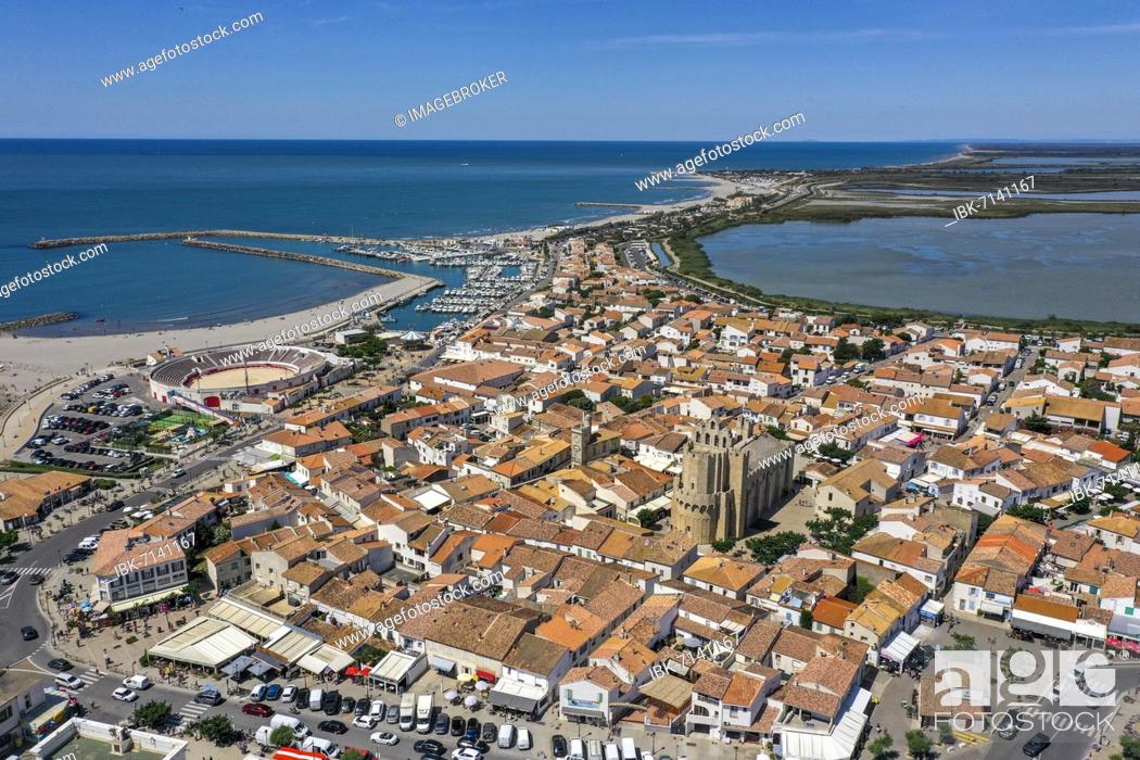 Stock Photo: Drone shot, drone photo of Saintes-Maries-de-la-Mer with old town, harbour, the church Notre Dame and the salt fields in the background.