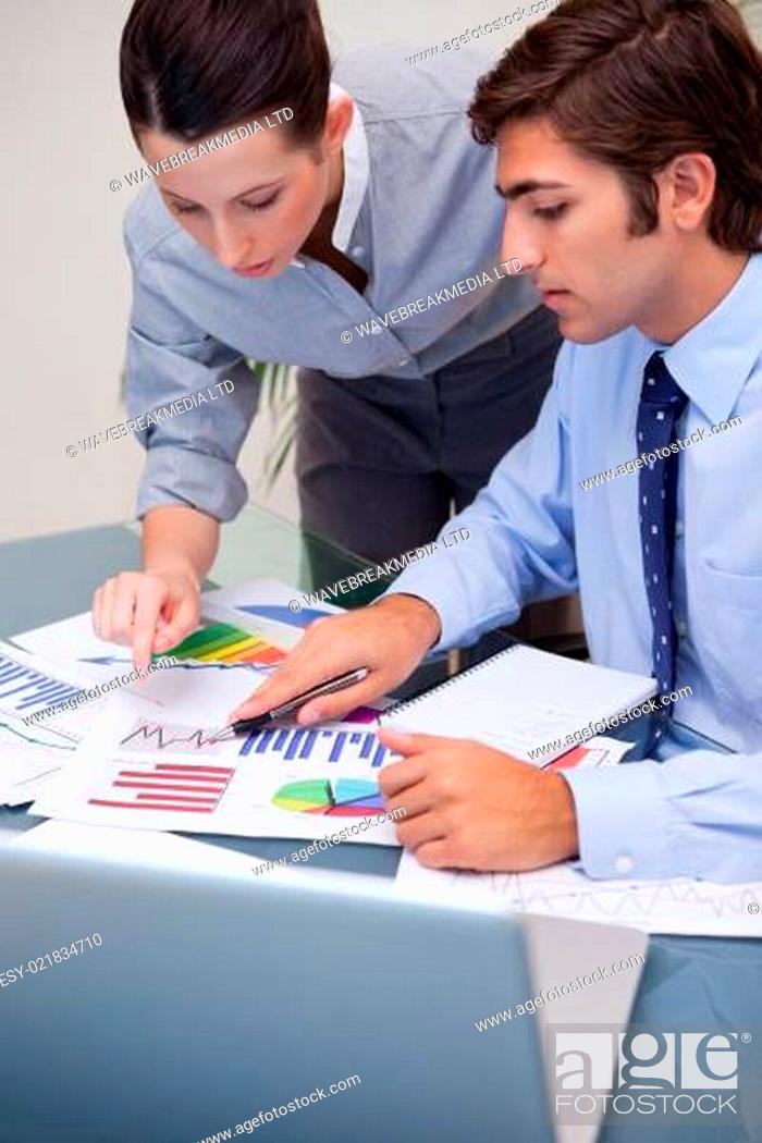 Stock Photo: Colleagues looking at business graphs at office.