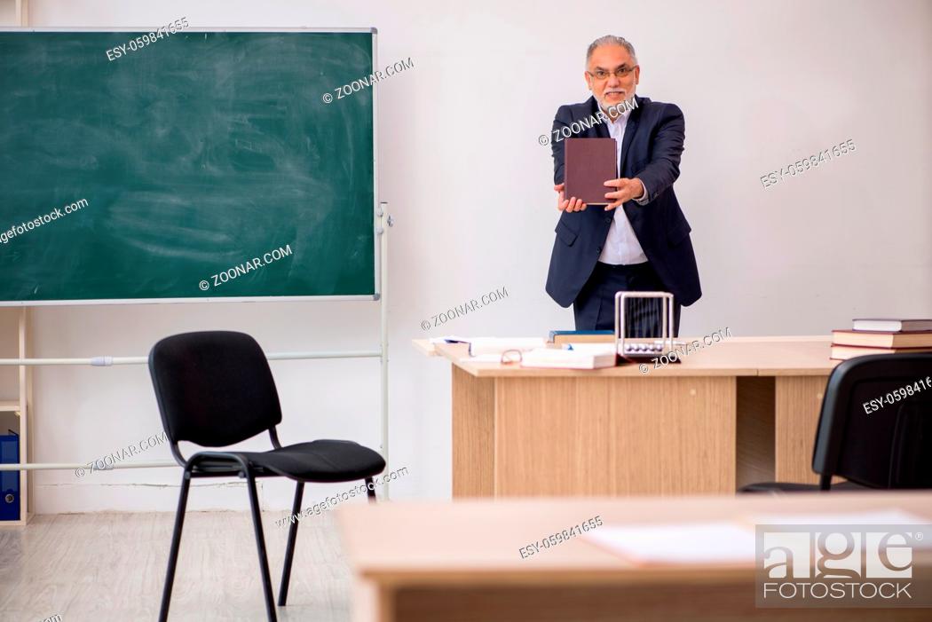 Stock Photo: Old teacher in front of blackboard.