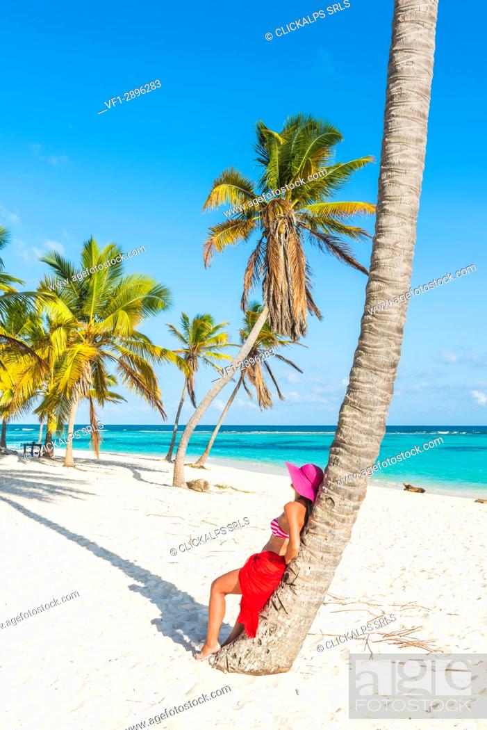 Photo de stock: Canto de la Playa, Saona Island, East National Park (Parque Nacional del Este), Dominican Republic, Caribbean Sea. Beautiful woman with red sarong relaxing on.