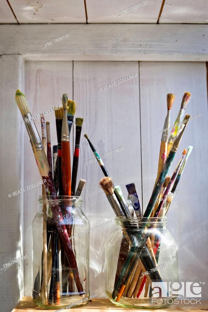 Stock Photo: Headline: Brushes in glasses on shelf.