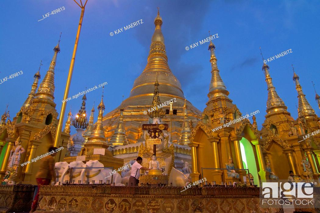 Stock Photo: Burmese man praying after sunset at the Shwedagon Paya, Yangon, Rangoon, Myanmar, Burma.