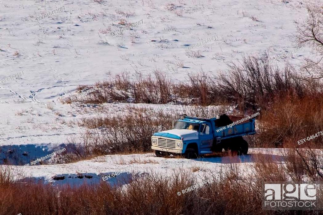 Stock Photo: A Old farm truck abandoned in the field and covered with snow.