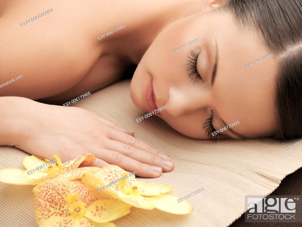 Imagen: health and beauty, resort and relaxation concept - asian woman in spa salon lying on the massage desk.