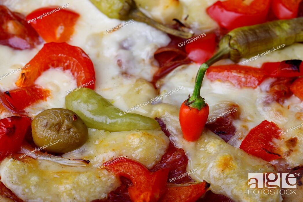 Stock Photo: red chili on a tasty pizza.