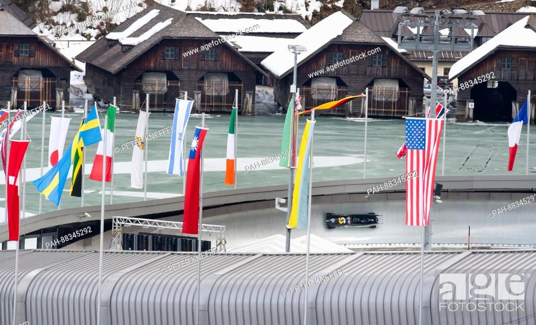 Stock Photo: The four-person Bob with Nick Cunningham and his team from the USA on the echo-curve lined with flags in Schoenau Am Koenigssee, Germany, 22 February 2017.