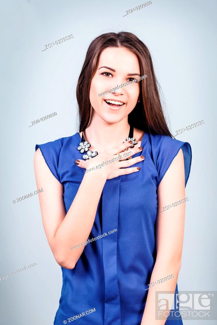 Stock Photo: Young surprised beautiful woman with smile on gray background.