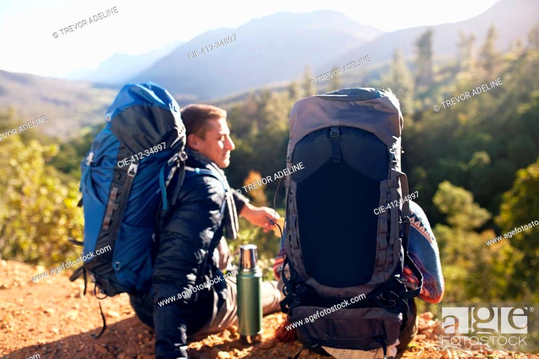 Stock Photo: Young couple with backpacks hiking, taking a coffee break.