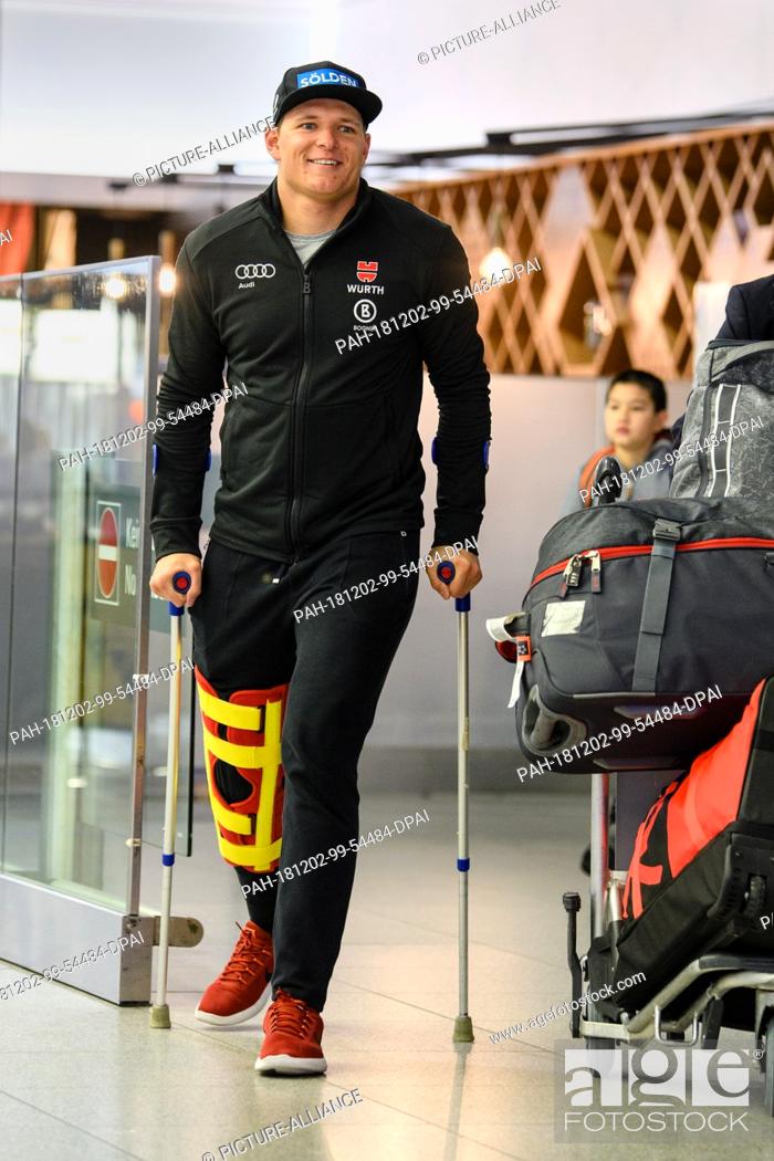 Stock Photo: 02 December 2018, Bavaria, München: Ski racer Thomas Dreßen arrives at the airport with forearm crutches after his heavy fall on the descent to Beaver Creek.