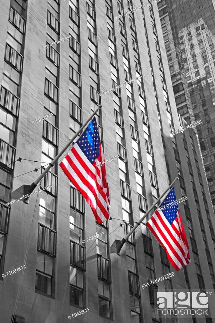 Stock Photo: Two American flags with skyscraper background. Monochromatic photo with color us flags.